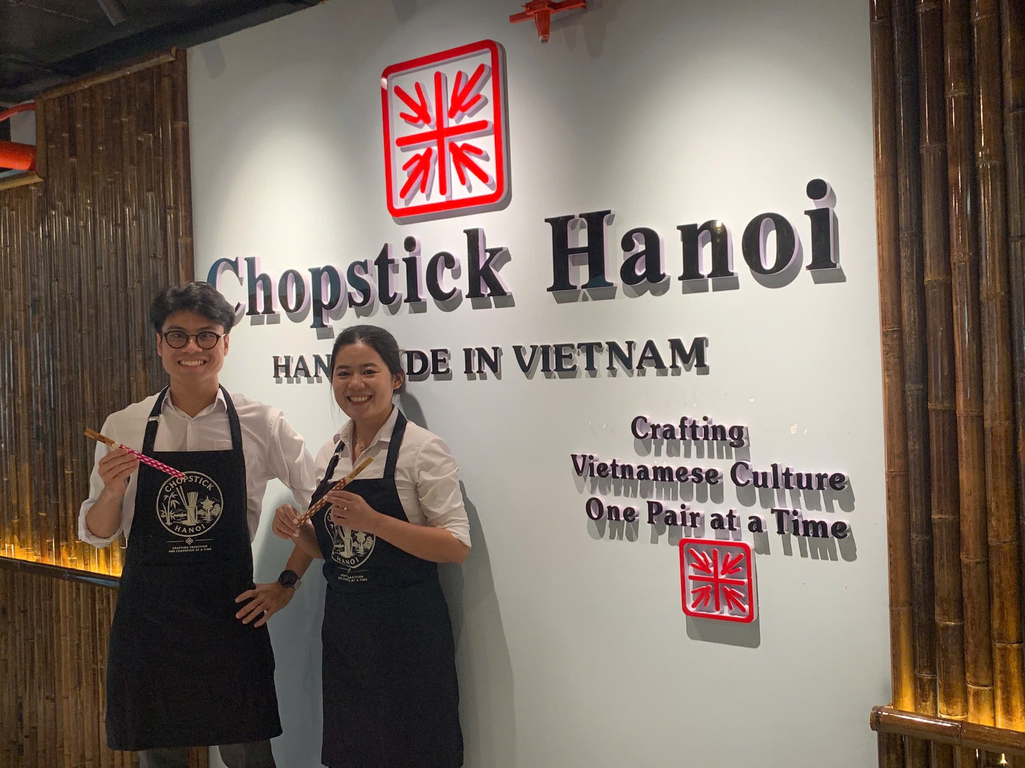 Two guests standing together with their finished chopsticks at Chopstick Hanoi