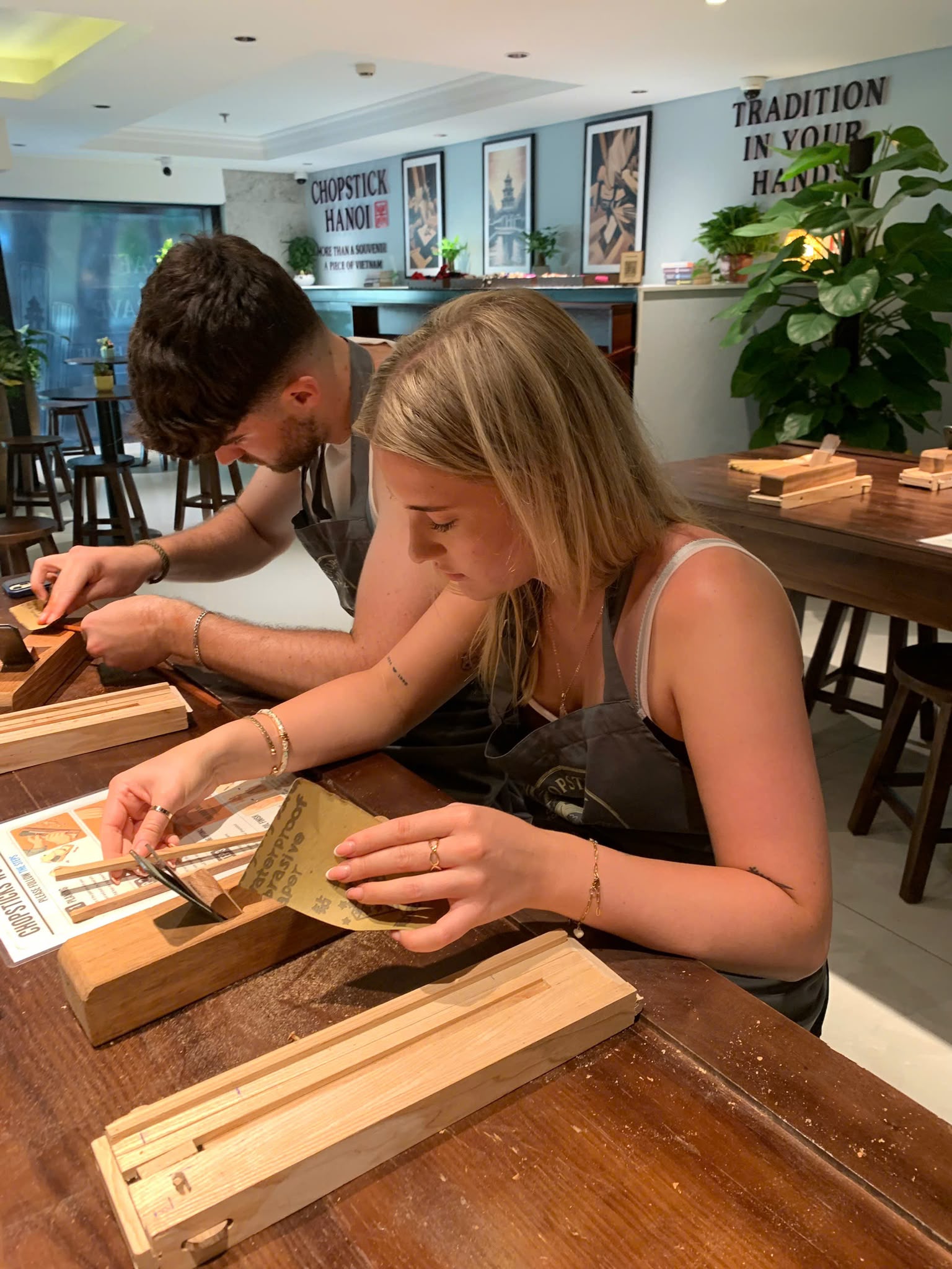 Two guests shaping wood together during the workshop