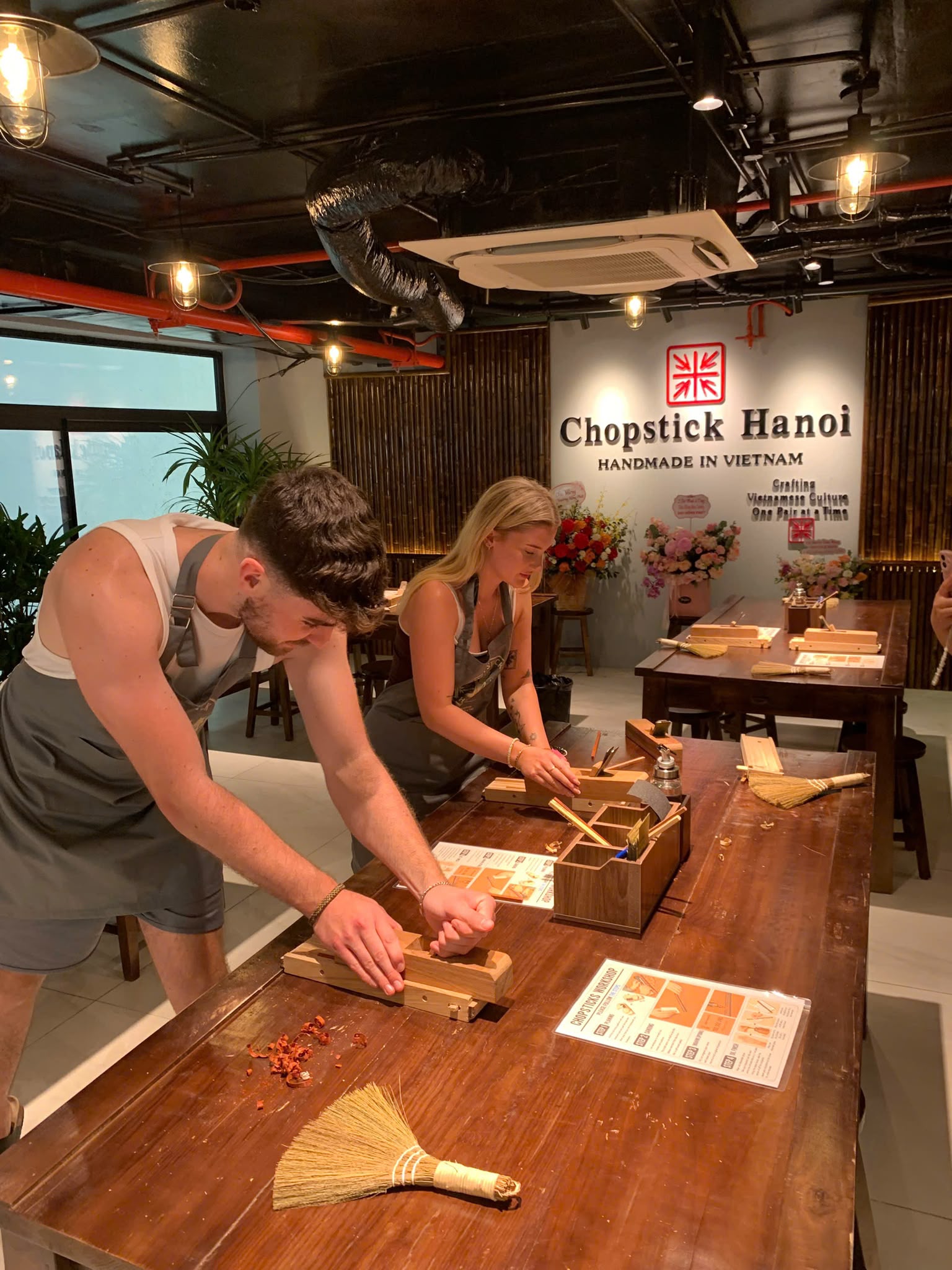 Two guests using hand planes to make their chopsticks
