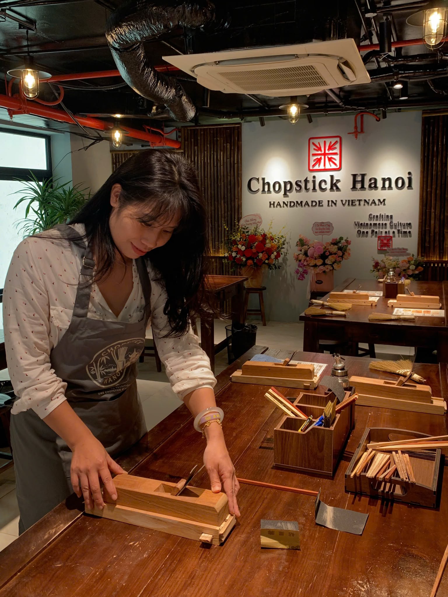 A guest carefully shaping a chopstick by hand