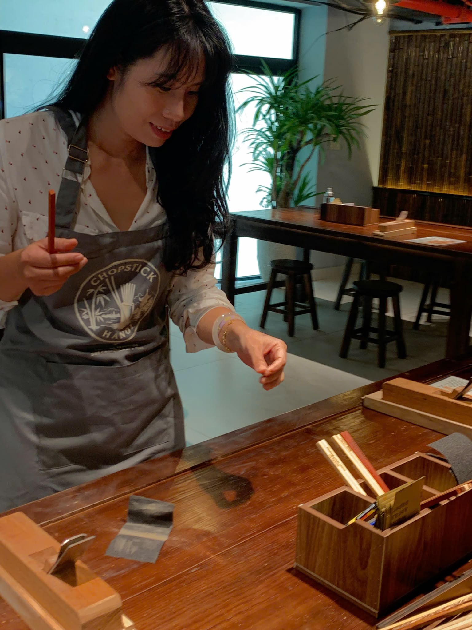 A guest showing her handcrafted chopstick at the workbench