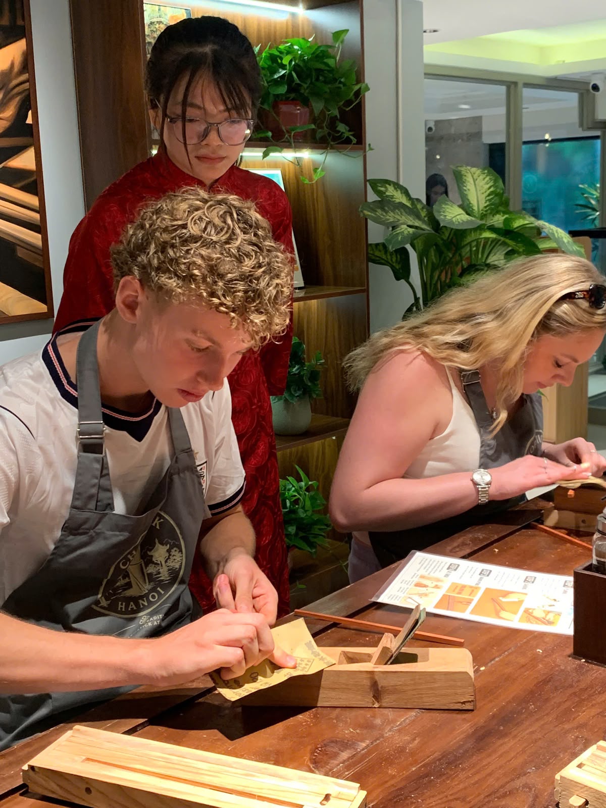 Guests sanding their handmade chopsticks with guidance from the Chopstick Hanoi team