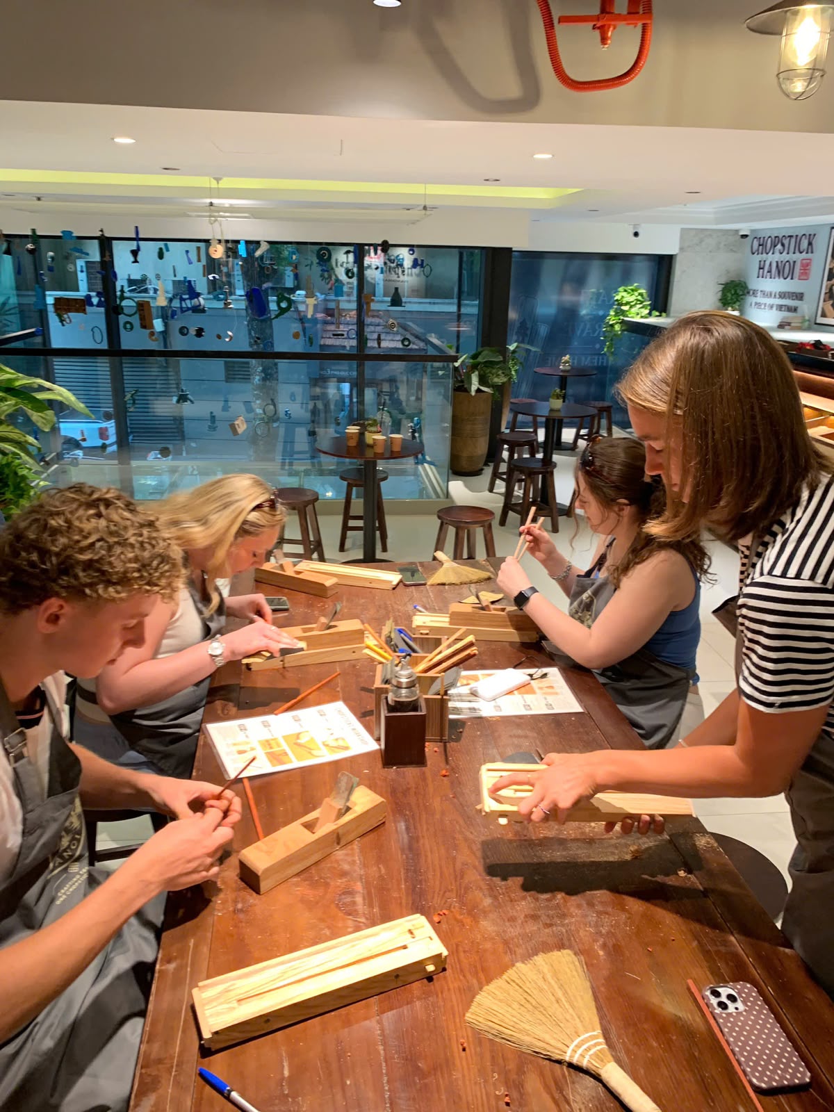 Guests carefully finishing their handmade chopsticks together