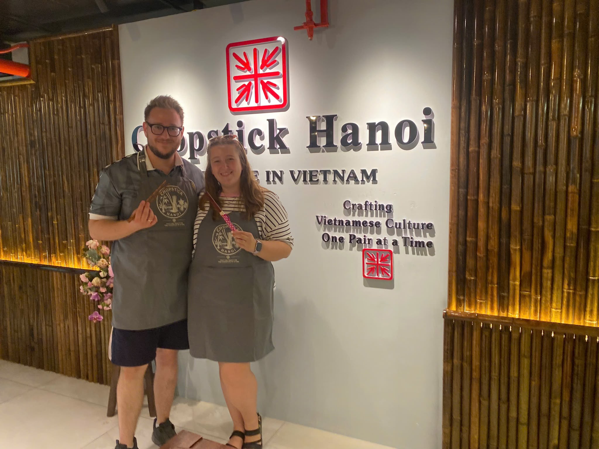 Two guests displaying their finished handmade chopsticks at Chopstick Hanoi