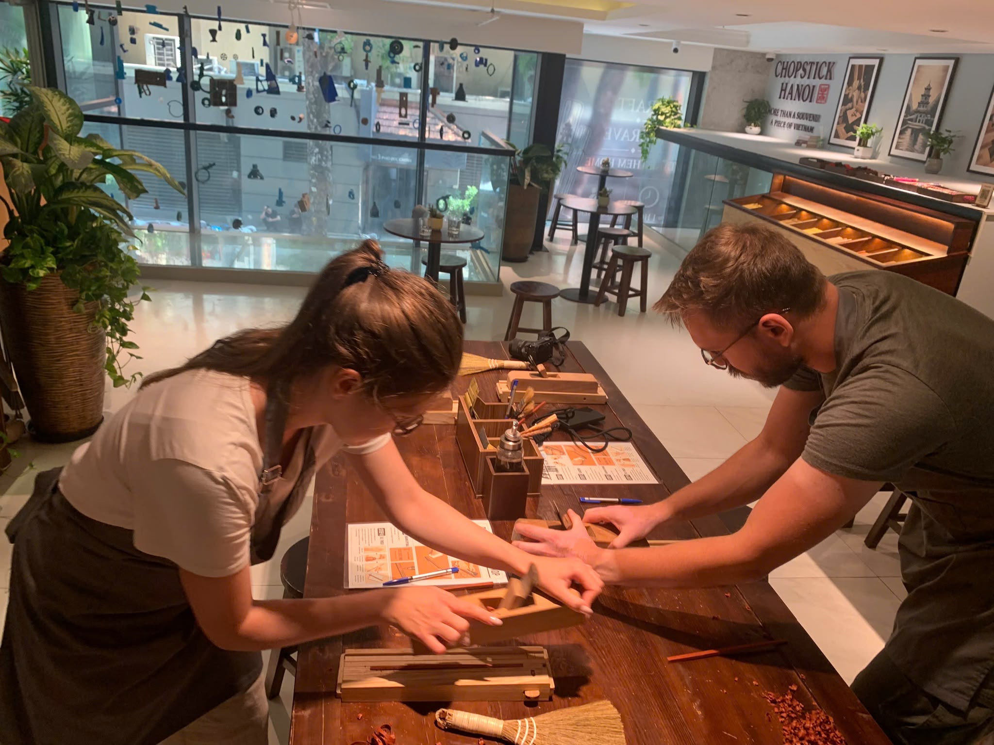 Two guests working together on their handmade chopsticks