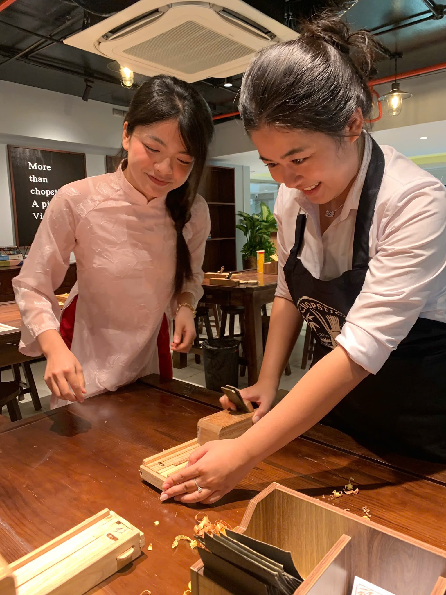 A guest learning to shape chopsticks by hand