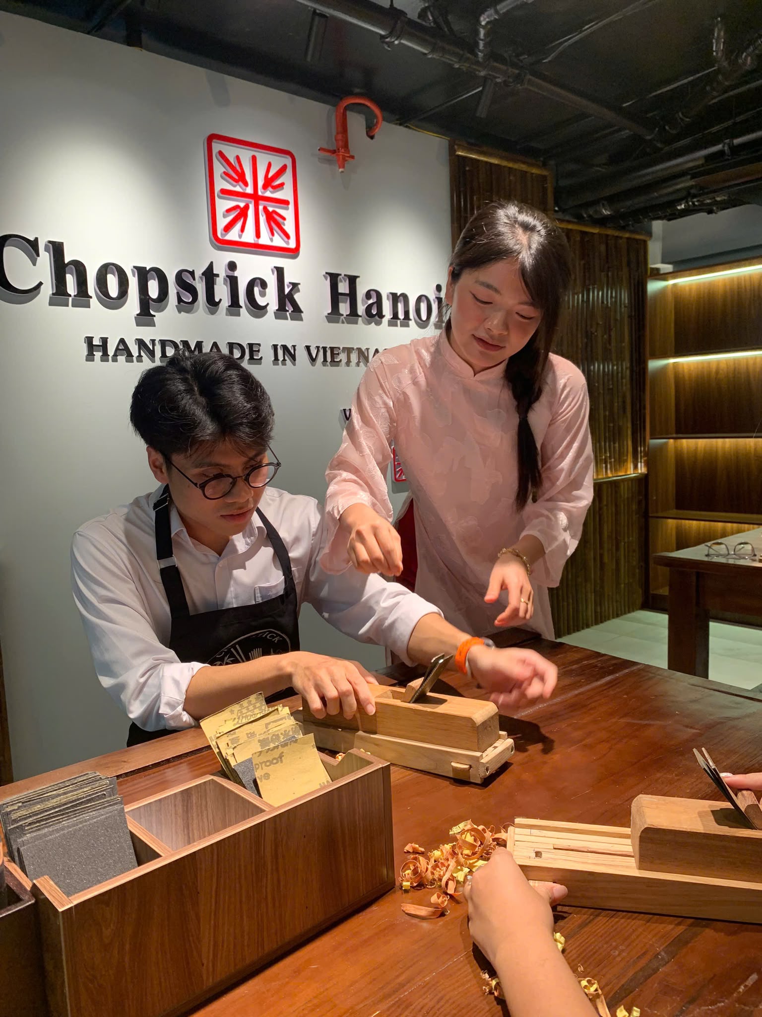 A guest receiving hands-on chopstick-making instruction